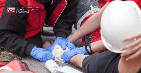 Image of medics bandaging a man in a hard hat