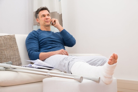 A man with a broken leg on the phone