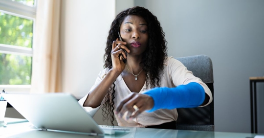 woman with cast on computer