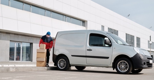 man lifting boxes into a delivery truck